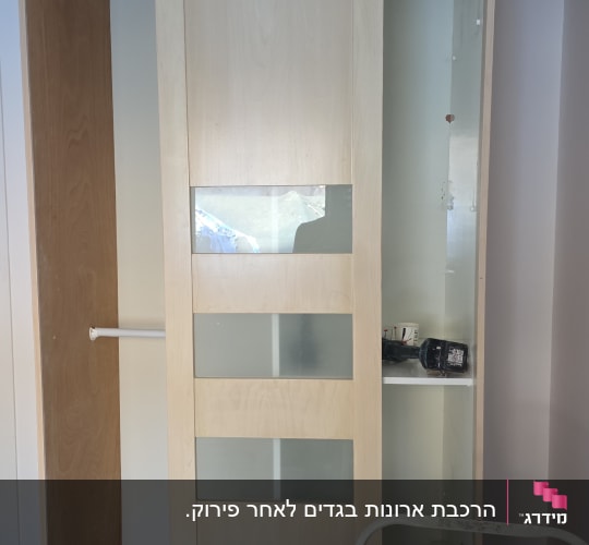 ארון עץ עם דלתות זכוכית וכלי עבודה בפנים